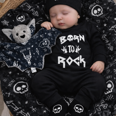 Bebé a dormir vestido com roupa preta com texto branco e detalhes de caveiras