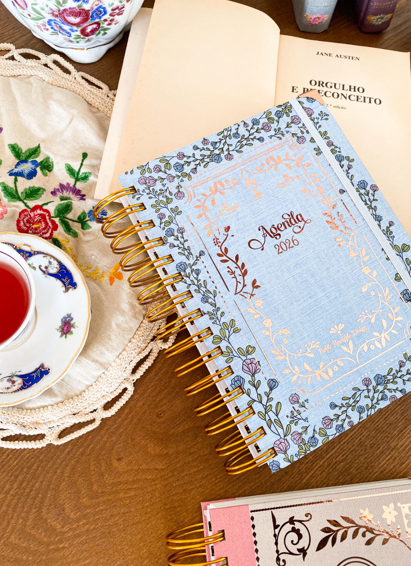 Agendas 2026 com capa azul clara e padrão floral com espiral dourada