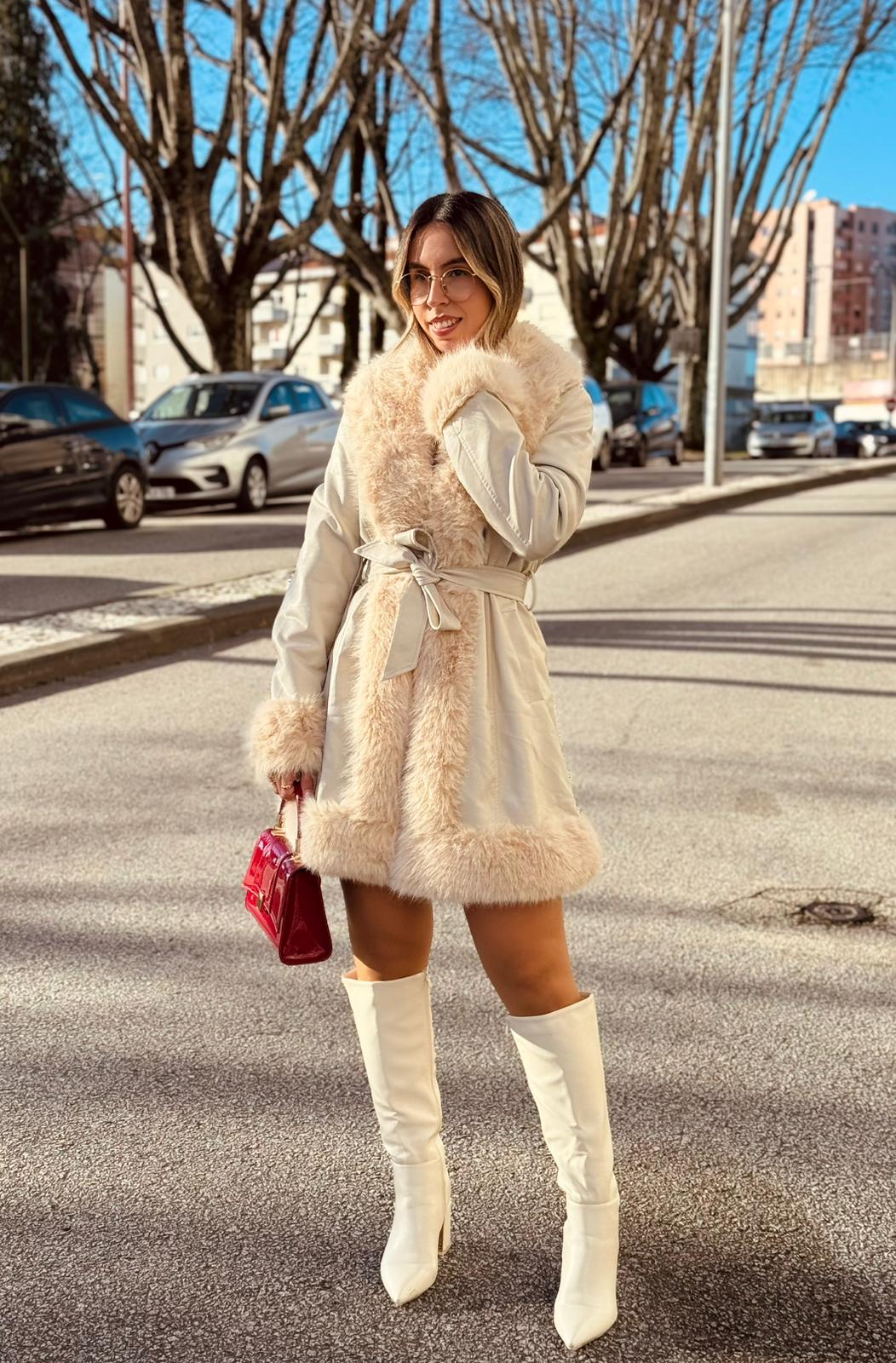 Casaco Napa c/ Pêlo Mulher com casaco de pelo bege, botas brancas e mala vermelha na rua