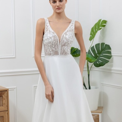 Vestido de noiva branco com corpete rendado e saia fluída em ambiente interior