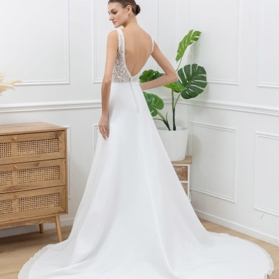 Vestido de noiva branco com saia longa e costas em renda, em ambiente interior claro.