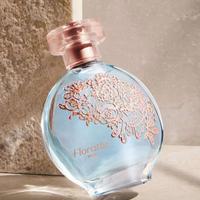Frasco de perfume azul com tampa rosa e padrão floral dourado