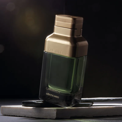 Frasco de perfume verde com tampa dourada em fundo escuro