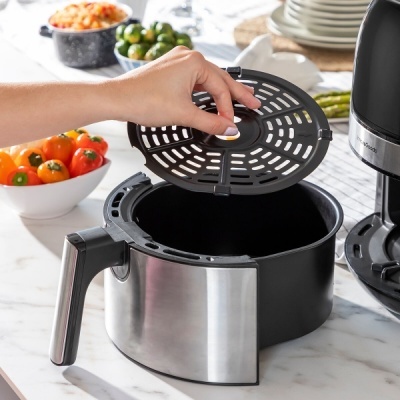 Recipiente para fritadeira sem óleo com tampa preta e punho em inox numa bancada de cozinha