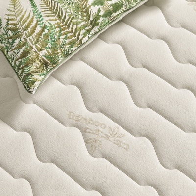 Colchão creme com bordado 'Bamboo' e almofada decorativa com estampa de folhas