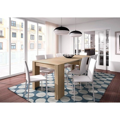 Sala de jantar com mesa de madeira clara, cadeiras brancas, tapete azul com círculos, candeeiros pendentes e portas de vidro