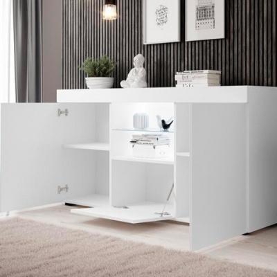 Aparador branco com portas abertas e decoração sobre o tampo