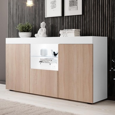 Aparador branco com portas de madeira clara e secção em vidro, com decoração interior e parede preta texturizada