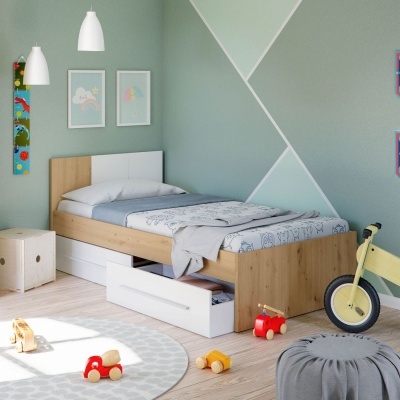 Quarto infantil com cama de solteiro em madeira clara, gavetas brancas, roupa de cama cinza e branca, brinquedos no chão e parede verde com padrões geométricos.