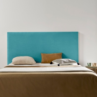 Cama com cabeceira azul-turquesa e roupa de cama castanha e bege, em ambiente minimalista