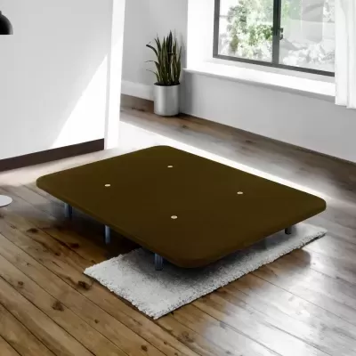 Base de cama castanha com pés metálicos sobre tapete cinza em chão de madeira