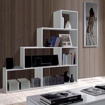 Estante branca modular com livros e objetos decorativos numa sala com parede de madeira.