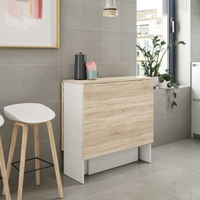 Móvel dobrável branco com madeira clara ao lado de banco alto e planta junto à janela