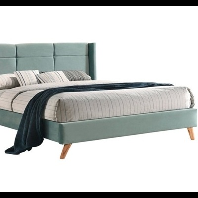 Cama estofada verde-azulado com roupa de cama e manta
