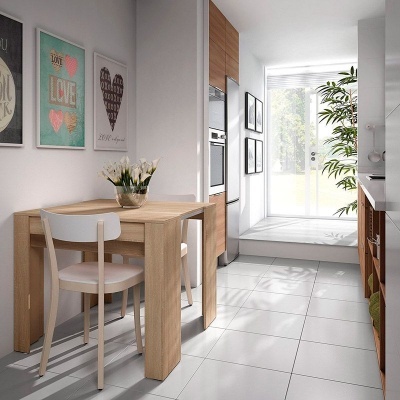 Cozinha com mesa de madeira e cadeiras brancas, quadros na parede e piso cinza claro