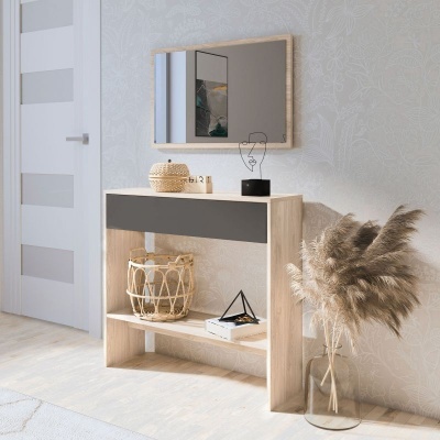 Móvel de entrada em madeira clara com gaveta preta, espelho e decoração com vaso e cesto