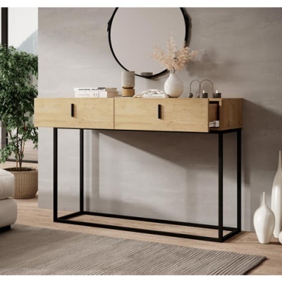 Aparador madeira clara com três gavetas e estrutura metálica preta decorado com vaso branco, livros e objetos pequenos num ambiente com vaso branco e planta verde