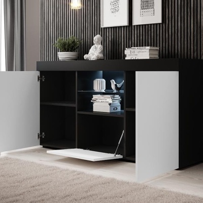 Móvel preto com portas brancas e objetos decorativos num ambiente interior moderno.