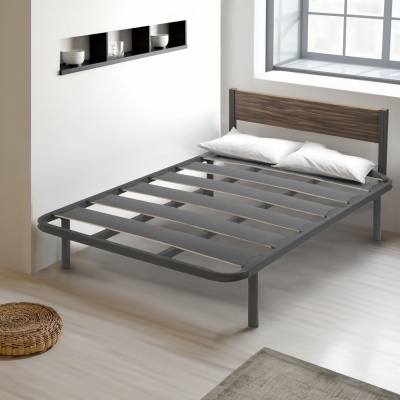 Cama com estrutura metálica cinzenta e cabeceira de madeira, colchão e almofadas brancas
