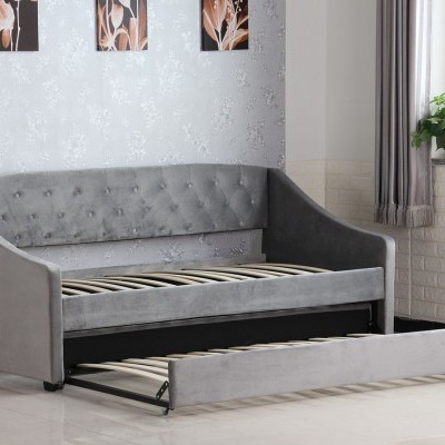 sofá cama cinza em sala clara com parede decorada e janelas com cortinas