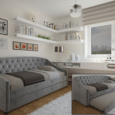 Sofá-cama cinzento acolchoado em sala com estantes, área de trabalho e janela com estores