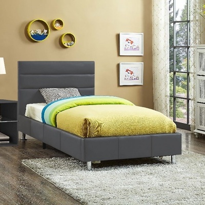 Cama individual cinza com roupa de cama verde e azul, mesa de cabeceira preta com candeeiro branco, tapete cinza, decoração de parede e armário branco junto à janela