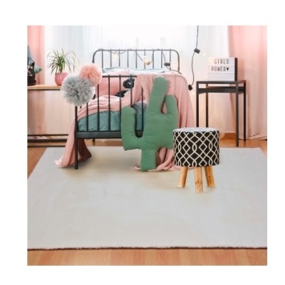 Quarto com cama de ferro, almofadas decorativas, puff e tapete claro