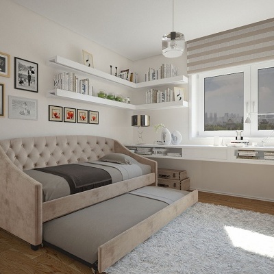 Quarto com cama dupla estofada bege, cama deslizante, estantes com livros, janelas com persiana às riscas, chão madeira e tapete cinza