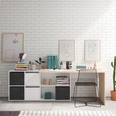 Mesa de escritório moderna com gavetas, livros, lupa, quadros minimalistas, cadeira preta e planta contra parede branca de tijolos.