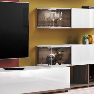 Móvel branco com vitrine de vidro, copos, escultura de porco e televisão numa sala.