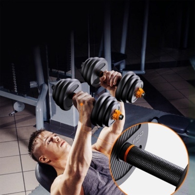 Homem a usar halteres ajustáveis cinza com detalhes laranja numa academia