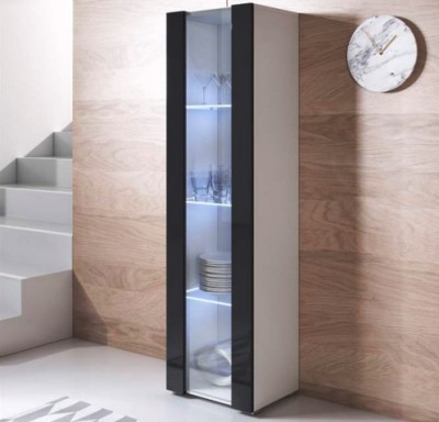 Móvel expositor alto com portas de vidro e laterais pretas, prateleiras com pratos e copos, parede de madeira clara e relógio de mármore