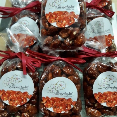Pacotes de amêndoas caramelizadas com etiqueta e fita vermelha