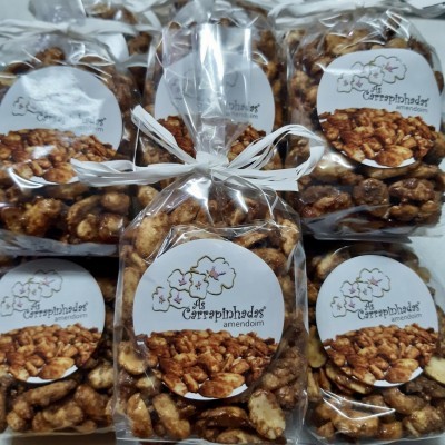 Pacotes de amêndoas caramelizadas com etiquetas brancas e laços.