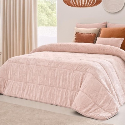 Colcha rosa com padrão de arcos e várias almofadas coloridas numa cama moderna