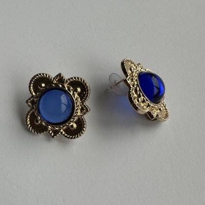 Brincos dourados com pedra azul e fecho de mola.
