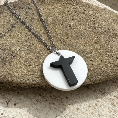 Colar com pendente redondo branco e símbolo preto de touro sobre pedra