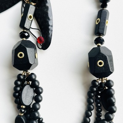 Colar preto multifacetado com detalhes metálicos dourados e estrela decorativa colorida