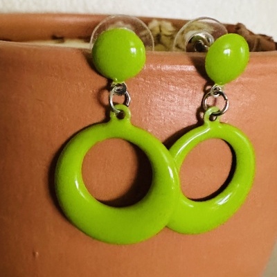 Brincos verdes circulares em vaso de cerâmica terracota