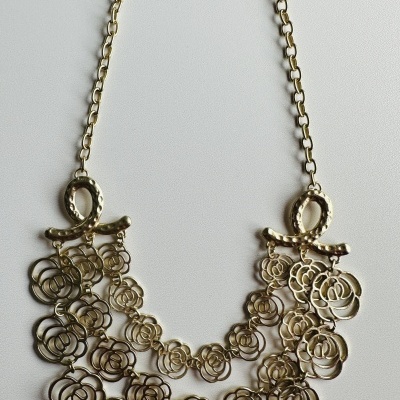 Colar metálico dourado com flores recortadas e correntes ajustáveis