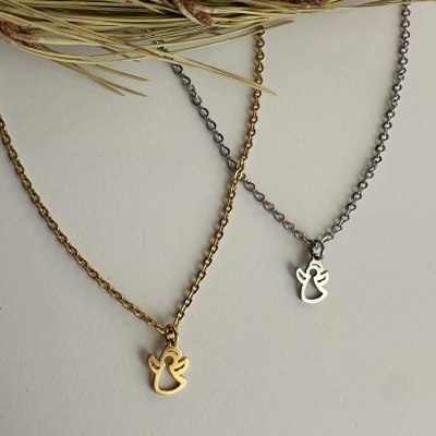 Dois colares com pendentes de anjo, um dourado e outro prateado, com ramos secos ao fundo