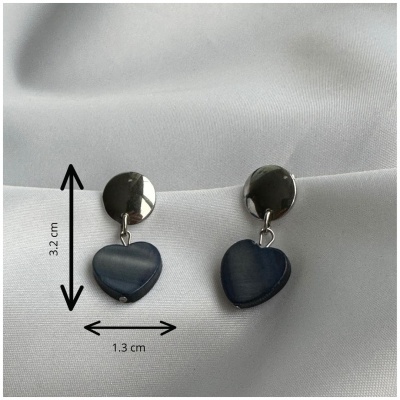 Brincos pendentes prateados com corações azuis sobre tecido branco.