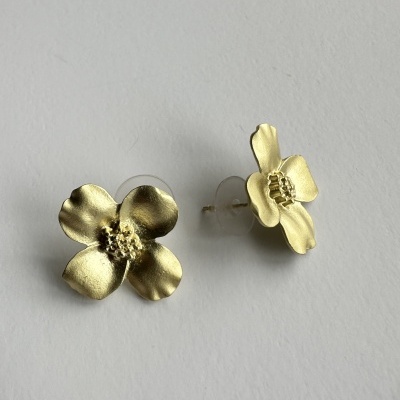 Brincos dourados em forma de flor com pétalas onduladas e centro texturizado