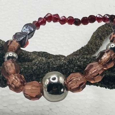 Pulseira com contas castanho-avelã e vermelhas translúcidas com conta metálica grande