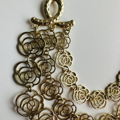 Colar dourado com flores vazadas e fecho oval texturizado