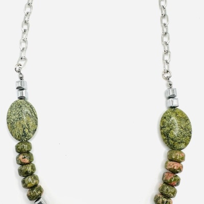 Colar com contas grandes verdes e prata com padrão floral, em fundo branco