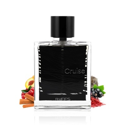 Frasco de perfume transparente com etiqueta preta e tampa preta, decorado com canela e frutas.