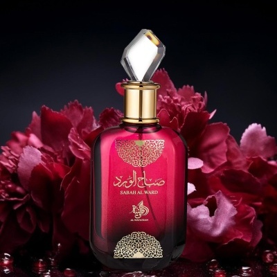 Frasco de perfume vermelho com tampa transparente, com decoração dourada e texto árabe e inglês