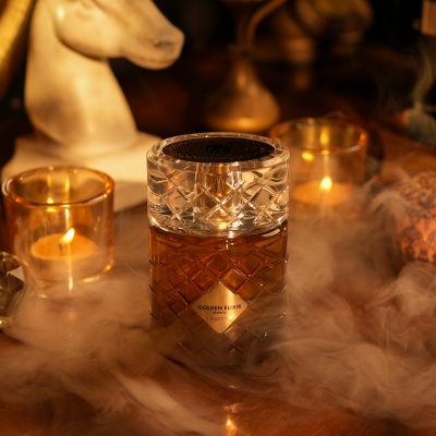 Frasco de licor GOLDEN ELIXIR RESERVE RiiFFS com textura quadriculada, velas acesas e decoração acolhedora