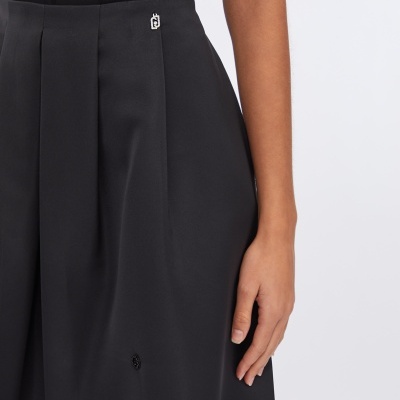 Saia preta com aplicações de contas e detalhe metálico no cós